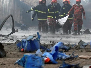 A group of firemen are in the background, while blue plastic debris from the blast is in the foreground Photo credit: AFP